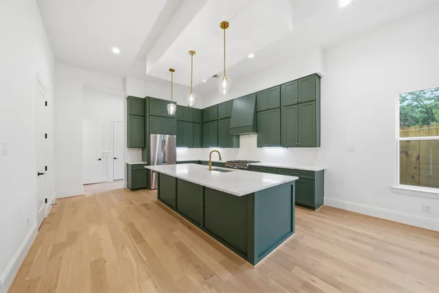 a kitchen with granite countertop a sink and a stove top oven