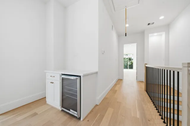 a view of a hallway with wooden floor and windows