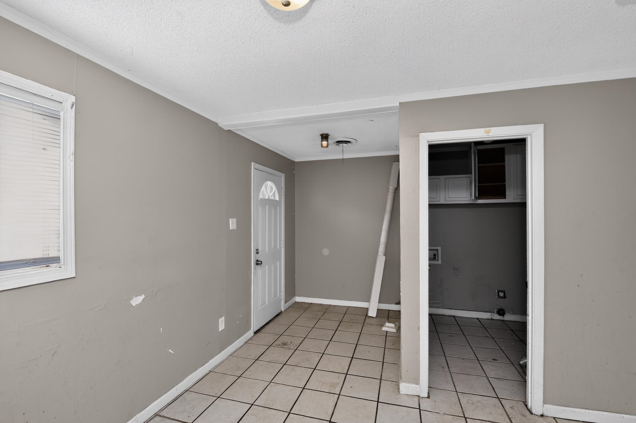 3791 Windermere Road Memphis, TN 38128 - Photo 18 of 18 Interior space featuring a white paneled entry door, light-toned tile flooring, and a window with blinds