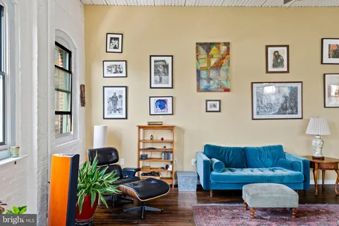 a living room with furniture a couch and paintings on the wall
