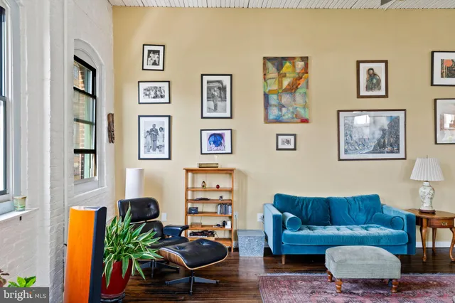 a living room with furniture a couch and paintings on the wall