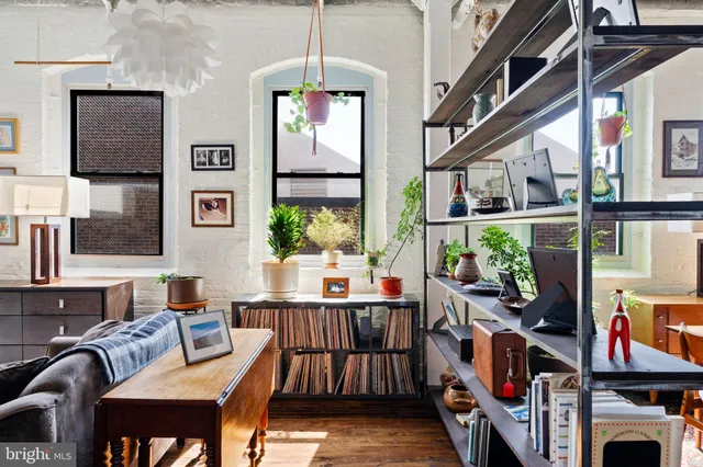 a living room with furniture a flat screen tv and a floor to ceiling window