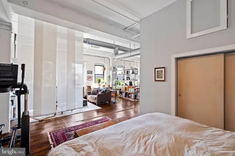 a bedroom with a bed couch and a window