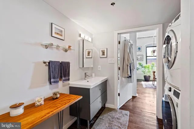 a view of a kitchen with fridge and wooden floor