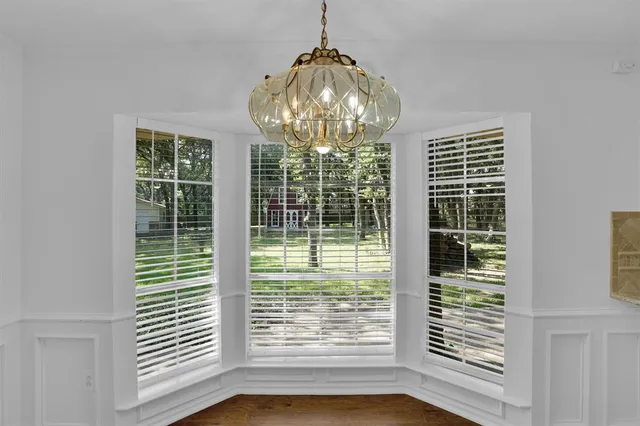 a view of empty room with wooden floor and windows