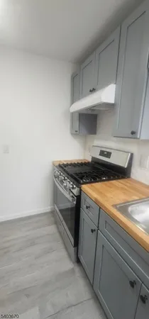 a kitchen with granite countertop a stove and cabinets