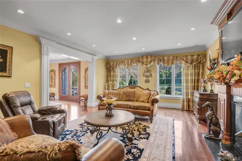 a living room with fireplace furniture and a large window