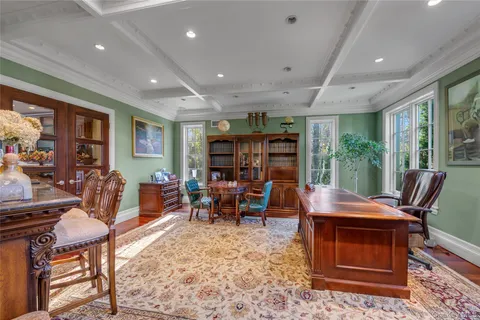 a living room with furniture a rug and a floor to ceiling window