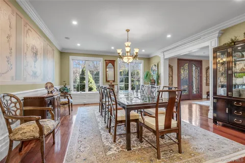 a dining room with furniture a chandelier and wooden floor
