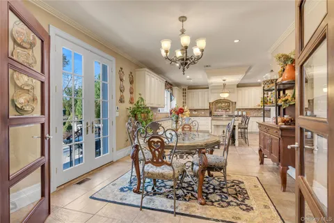 a view of a dining room with furniture a chandelier and wooden floor