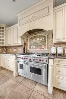 a kitchen with stainless steel appliances granite countertop a stove and a white cabinets
