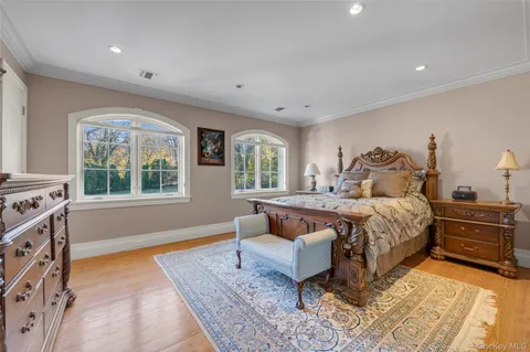 a spacious bedroom with a bed and wooden floor