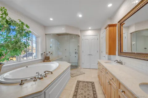 a spacious bathroom with a tub sink and mirror