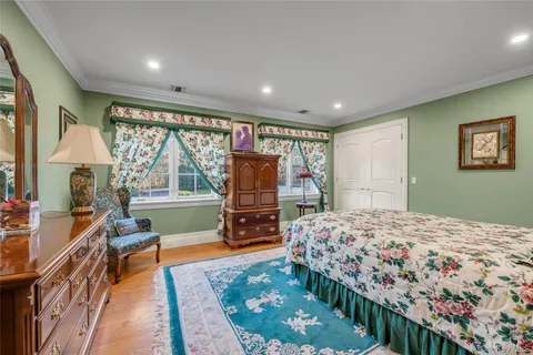a bedroom with a bed and a flat tv screen on the dresser