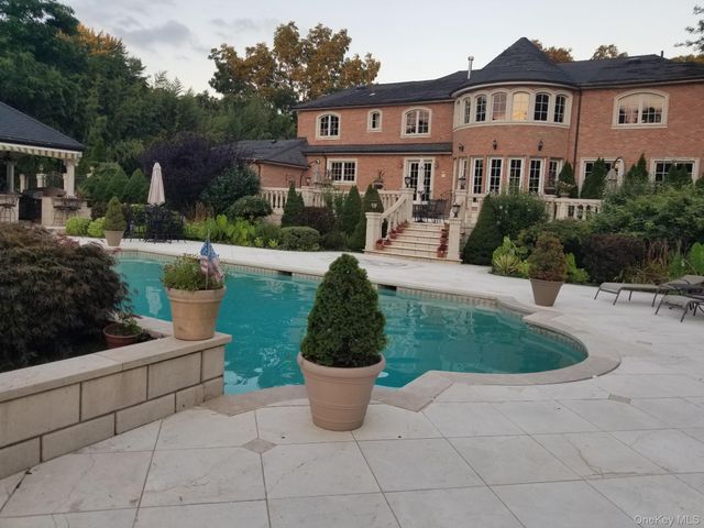 a view of a white house next to a yard and potted plants