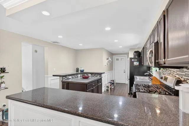 a kitchen with stainless steel appliances granite countertop a sink stove and refrigerator
