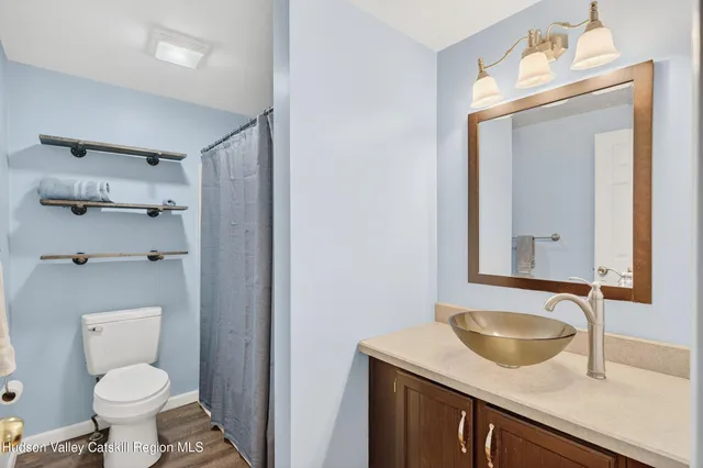 a bathroom with a granite countertop sink toilet and mirror