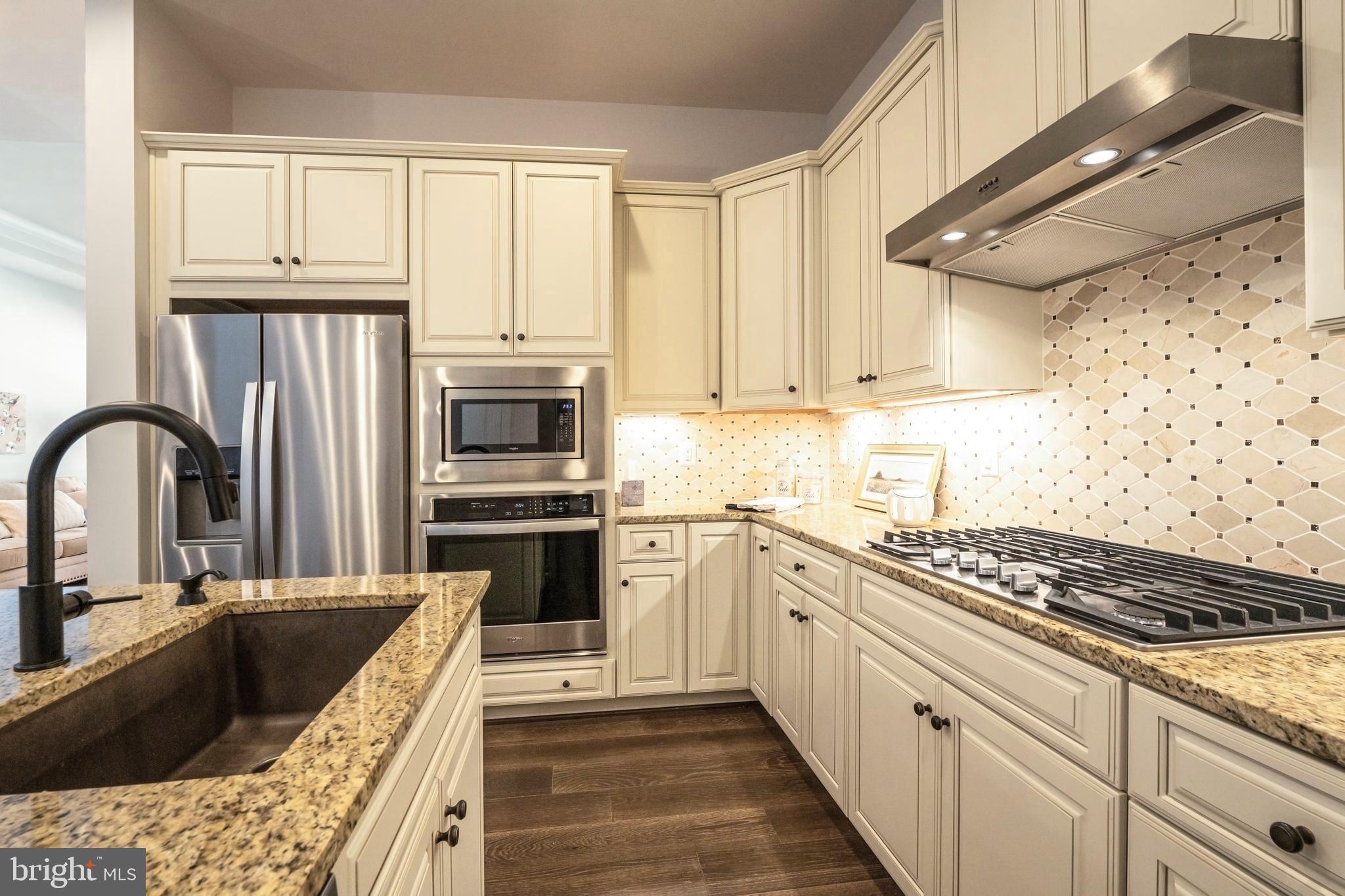 23716 September Sun Square Ashburn, VA 20148 - Photo 11 of 48 a kitchen with stainless steel appliances granite countertop a stove sink and cabinets