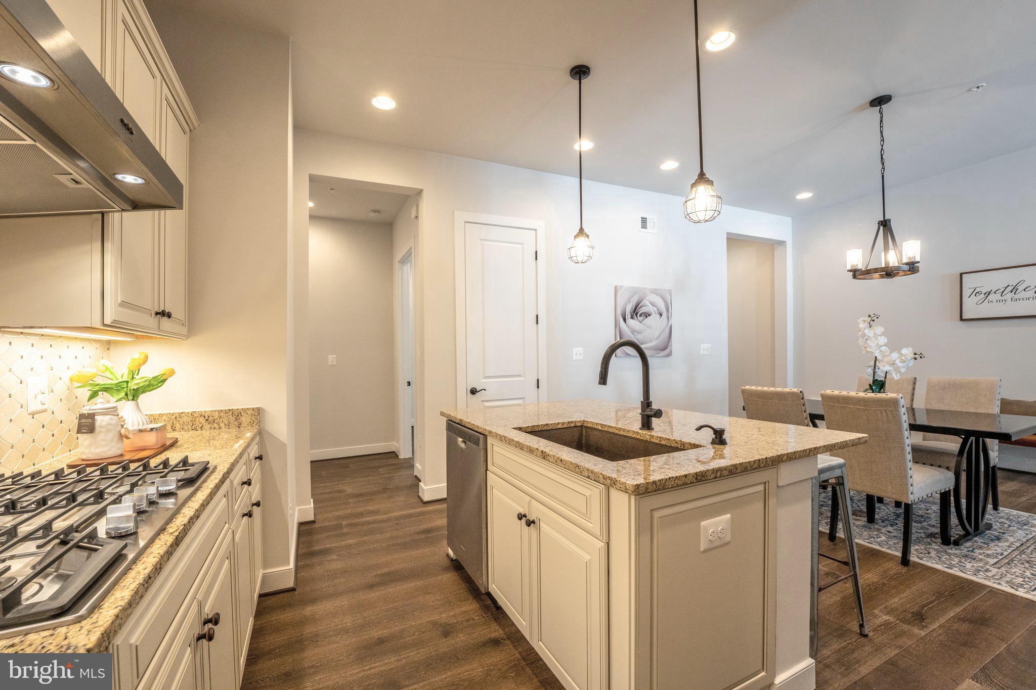 23716 September Sun Square Ashburn, VA 20148 - Photo 12 of 48 a kitchen with a sink stove and wooden floor