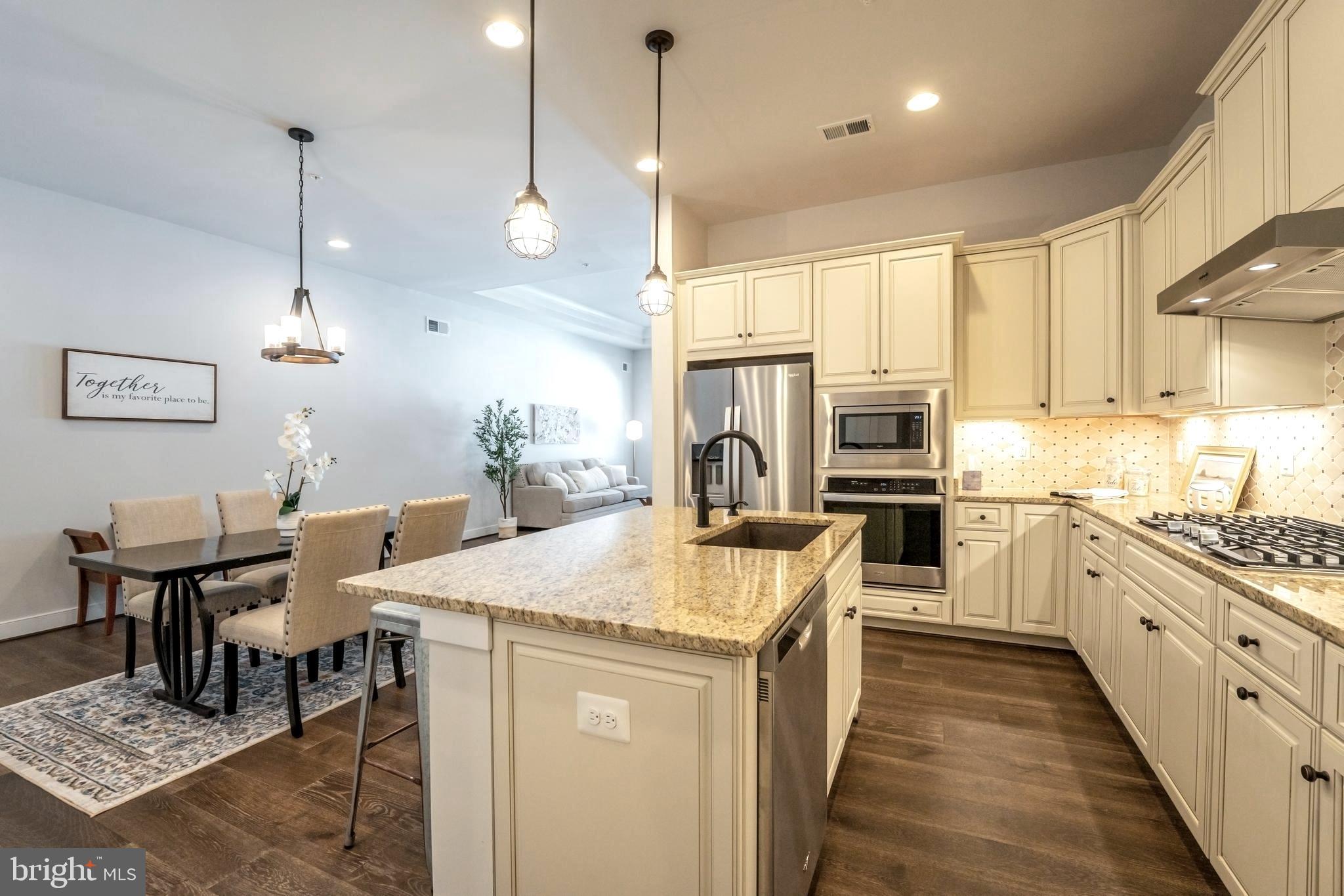 23716 September Sun Square Ashburn, VA 20148 - Photo 10 of 48 a kitchen with stainless steel appliances kitchen island granite countertop a sink a stove and a refrigerator