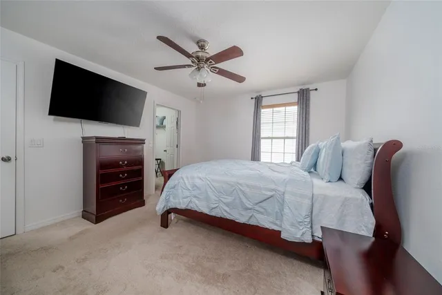 a spacious bedroom with a bed and a flat screen tv