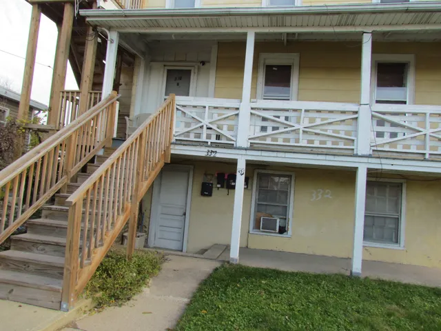 a front view of a house with glass windows and stairs