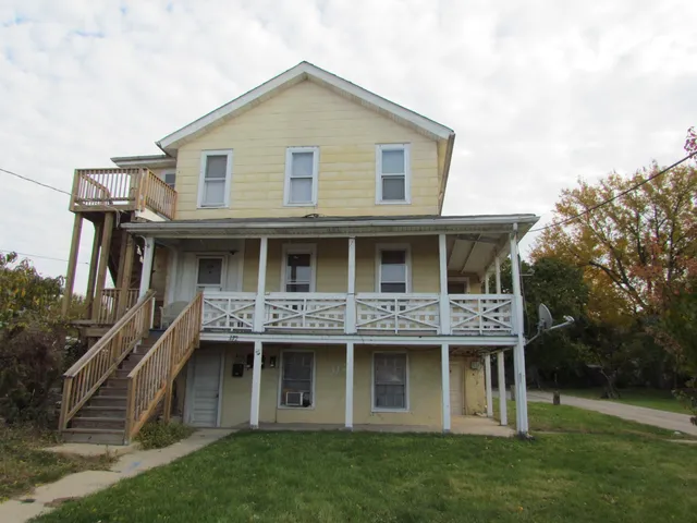 a front view of a house with a yard and trees