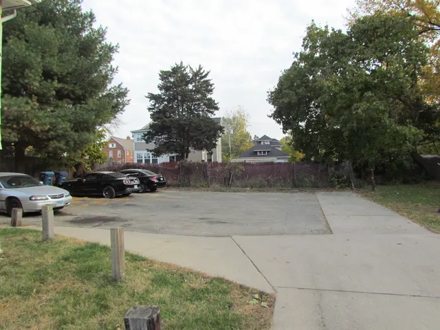 a view of a house with a cars park side of a road