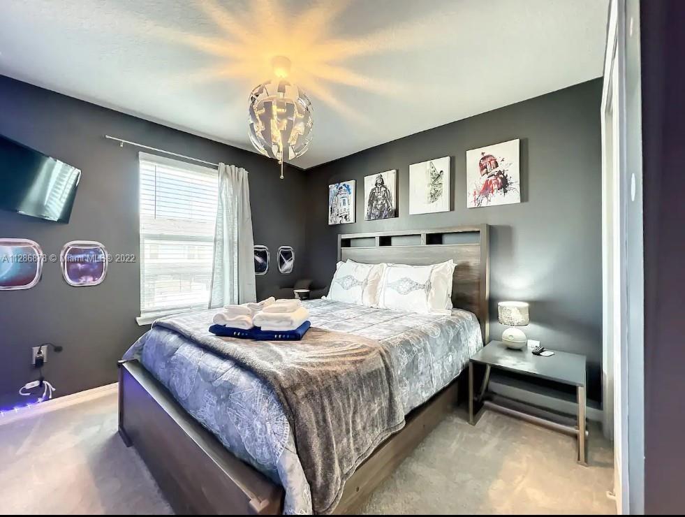 7108 Oakmoss Loop Davenport, FL 33837 - Photo 11 of 20 a bedroom with a bed and a table with lamp