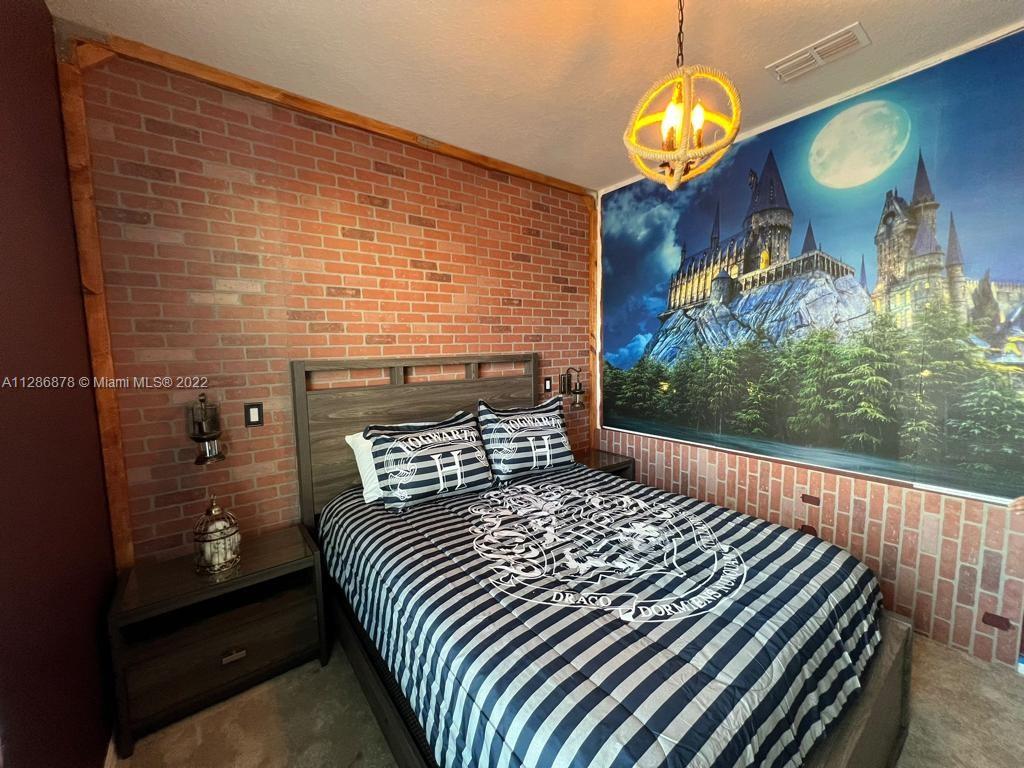 7108 Oakmoss Loop Davenport, FL 33837 - Photo 12 of 20 a bedroom with a bed and a chandelier