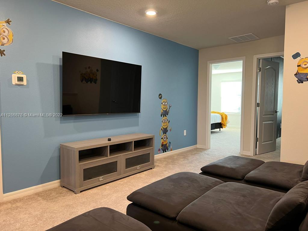 7108 Oakmoss Loop Davenport, FL 33837 - Photo 15 of 20 a living room with furniture and a flat screen tv