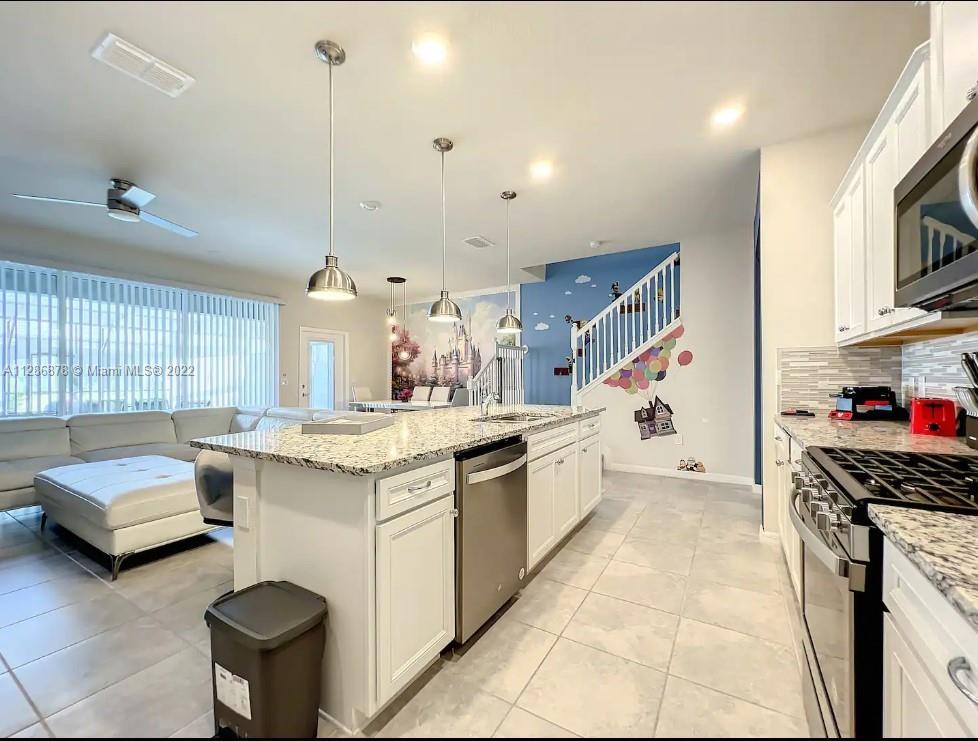 7108 Oakmoss Loop Davenport, FL 33837 - Photo 8 of 20 a kitchen with stainless steel appliances granite countertop a sink and a stove