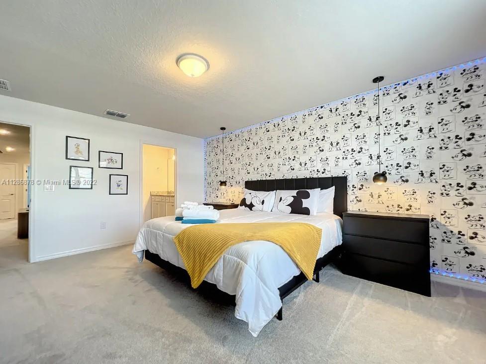 7108 Oakmoss Loop Davenport, FL 33837 - Photo 9 of 20 a bed sitting in a bedroom next to a window with wall paintings