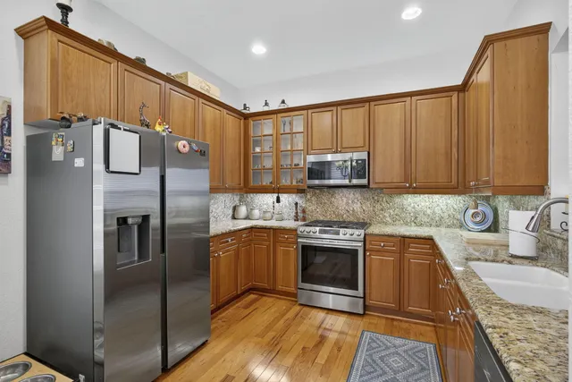 a spacious bathroom with sinks granite countertop a sink and a wooden floor
