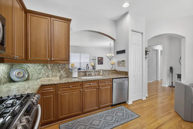 a dining room with wooden floor a chandelier a wooden table and chairs