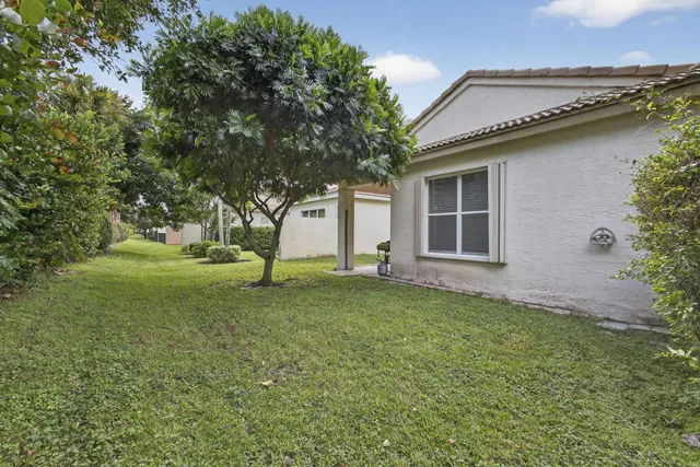 a front view of a house with a yard and potted plants