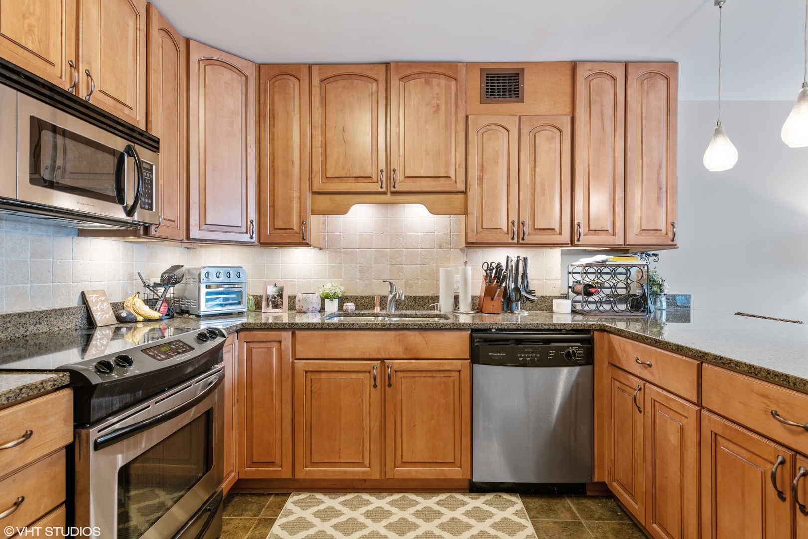 1030 North State Street, Unit 9K Chicago, IL 60610 - Photo 4 of 12 a kitchen with stainless steel appliances granite countertop a stove a sink and a microwave
