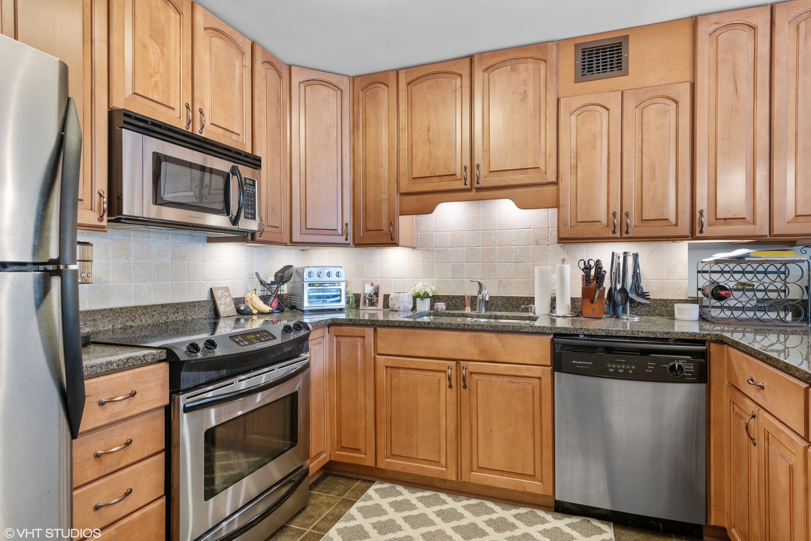 1030 North State Street, Unit 9K Chicago, IL 60610 - Photo 5 of 12 a kitchen with granite countertop a sink stove and cabinets