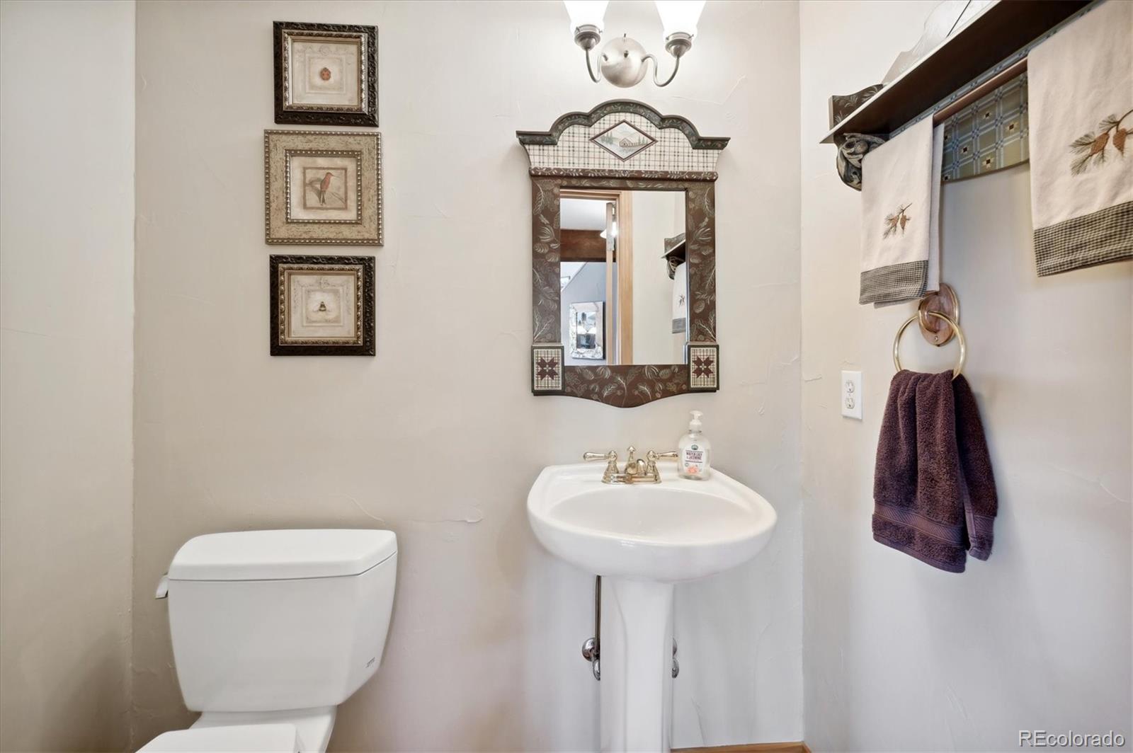 4671 Independence Trail Evergreen, CO 80439 - Photo 11 of 39 a bathroom with a toilet sink and mirror