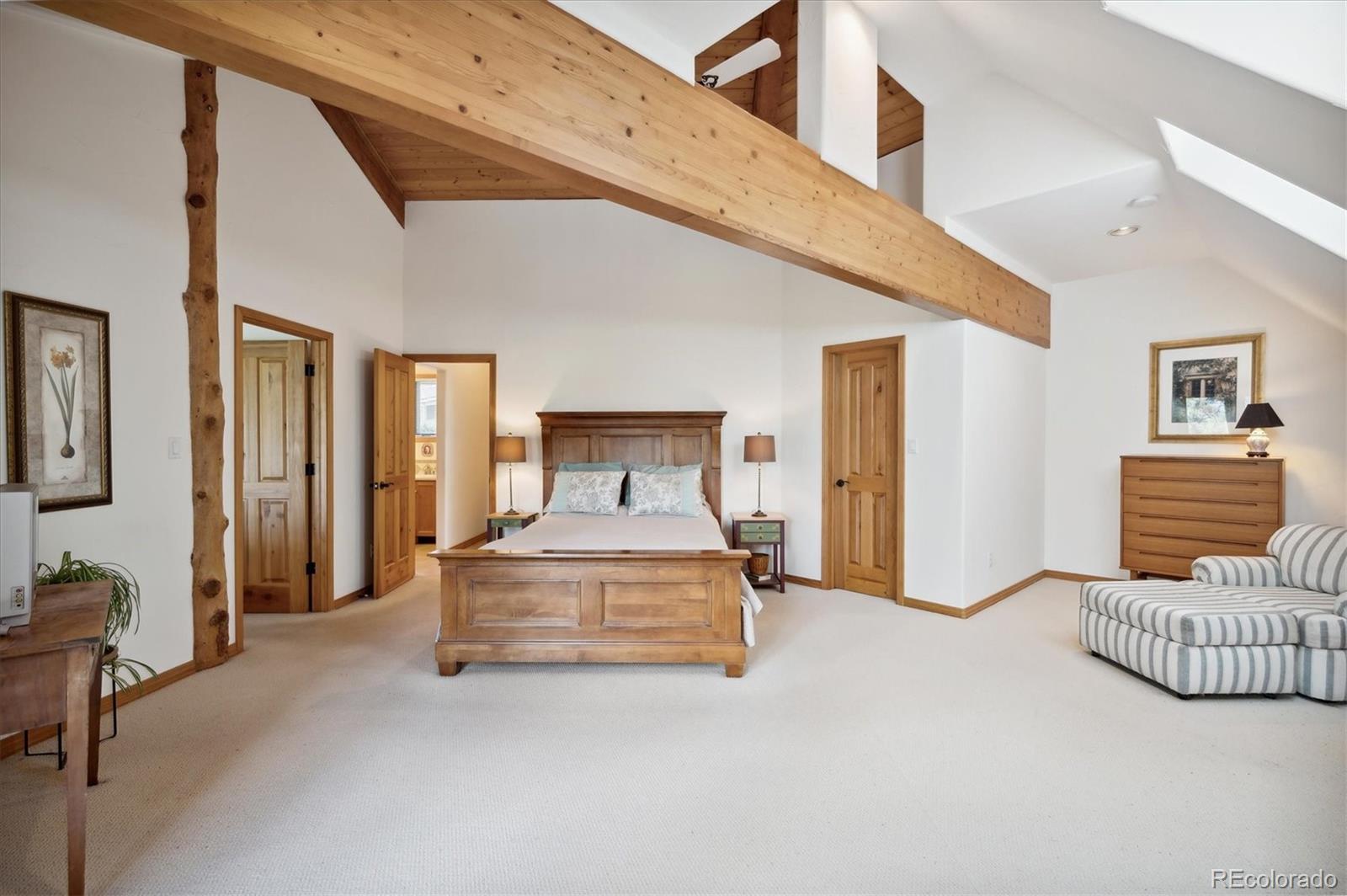 4671 Independence Trail Evergreen, CO 80439 - Photo 15 of 39 a spacious bedroom with a bed a couch and dresser