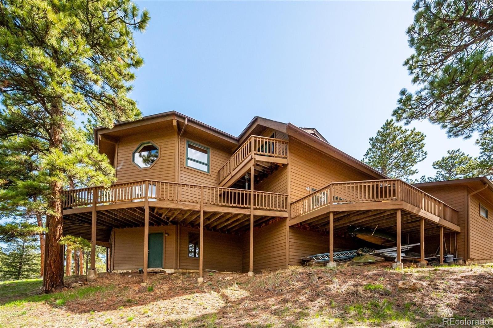 4671 Independence Trail Evergreen, CO 80439 - Photo 30 of 39 a front view of a house with a yard and garage