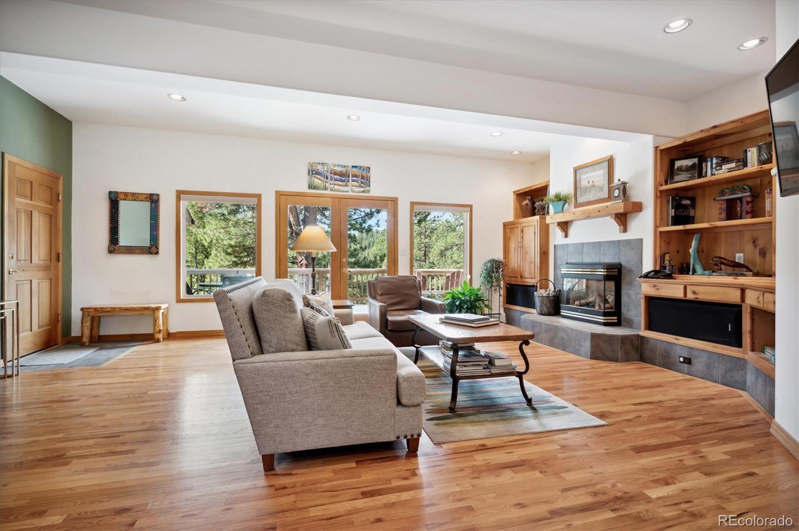 4671 Independence Trail Evergreen, CO 80439 - Photo 3 of 39 a living room with fireplace furniture and a wooden floor