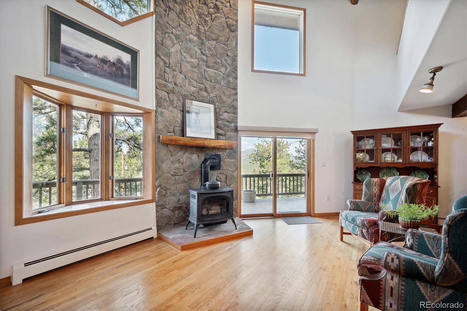 4671 Independence Trail Evergreen, CO 80439 - Photo 5 of 39 a living room with furniture a bookshelf and a fireplace