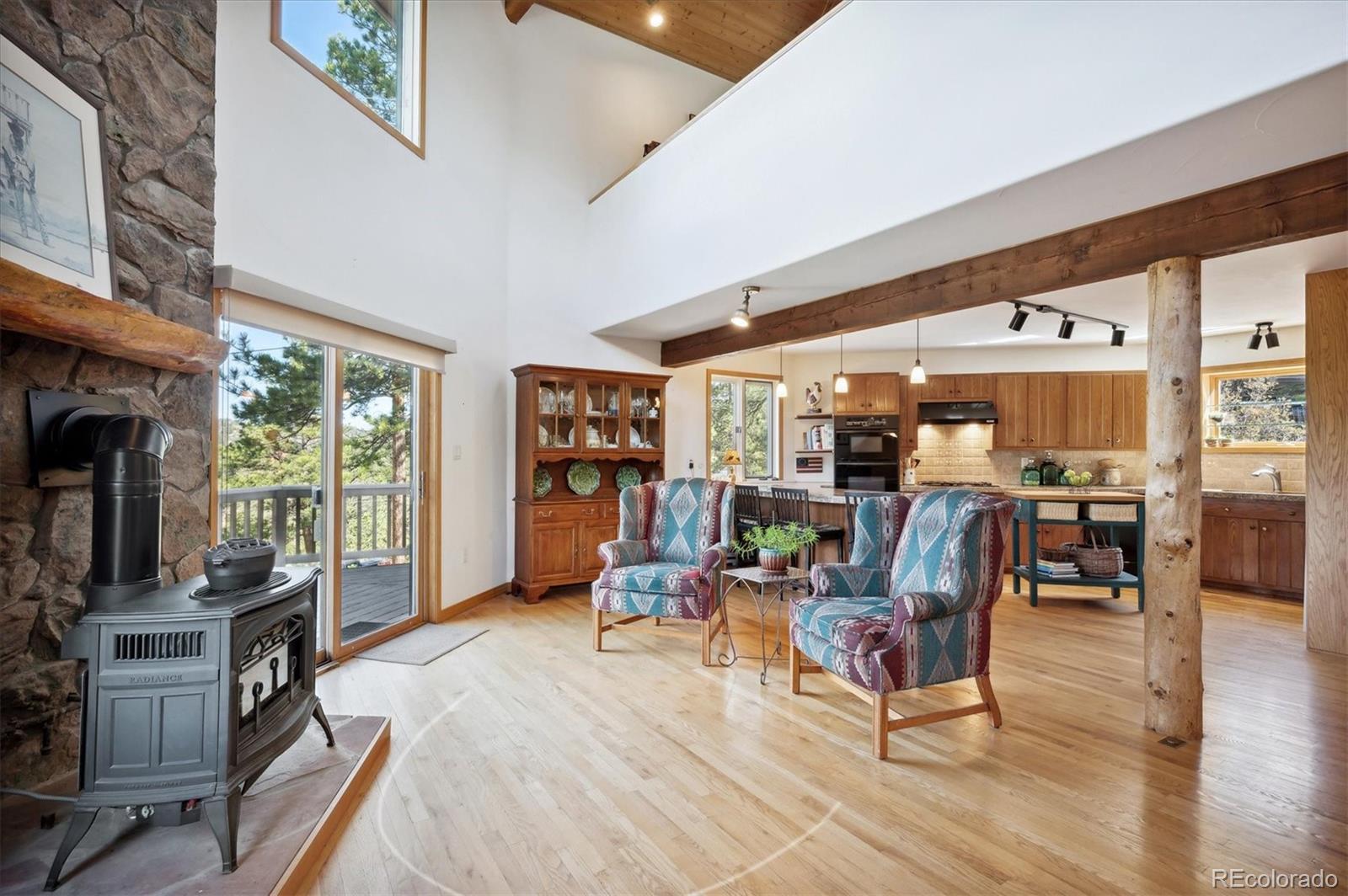 4671 Independence Trail Evergreen, CO 80439 - Photo 7 of 39 a living room with furniture a flat screen tv and floor to ceiling windows