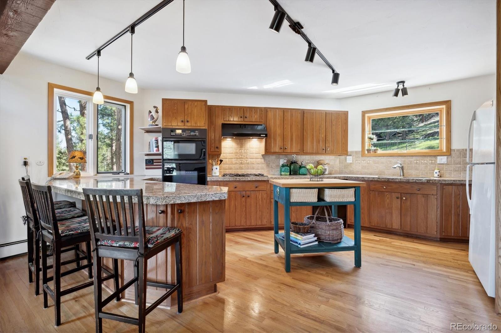 4671 Independence Trail Evergreen, CO 80439 - Photo 9 of 39 a kitchen with a table chairs sink and cabinets