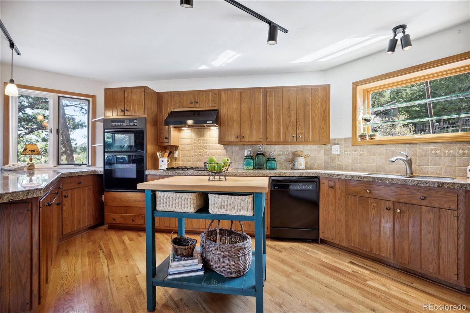 4671 Independence Trail Evergreen, CO 80439 - Photo 10 of 39 a kitchen with stainless steel appliances granite countertop wooden cabinets a stove and a sink