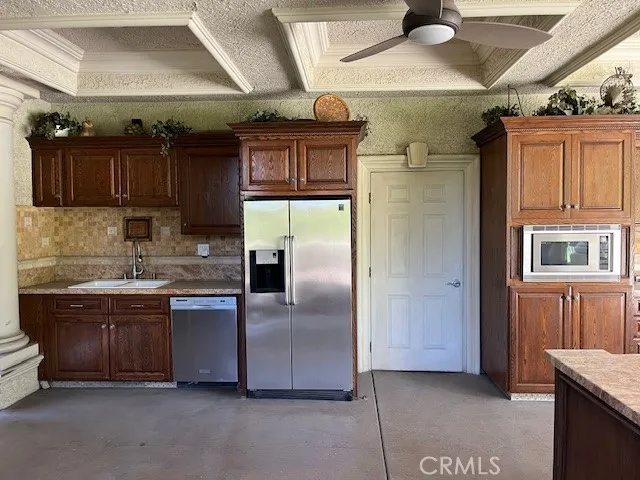 a kitchen with stainless steel appliances granite countertop a wooden cabinets a stove and a refrigerator