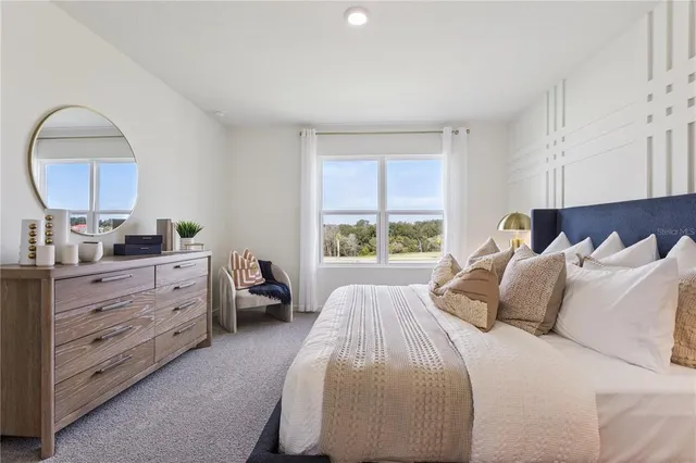 a bedroom with a bed and a mirror on dresser