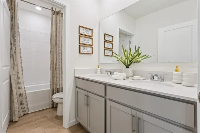 a bathroom with a granite countertop sink a toilet and a mirror