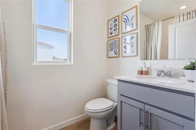 a bathroom with a toilet sink vanity and mirror